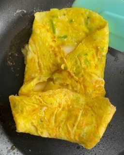 Una frittata gialla viene cotta in una padella