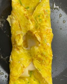 Una frittata gialla viene cotta in una padella.