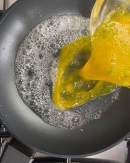Le uova vengono versate in una padella sul fornello.