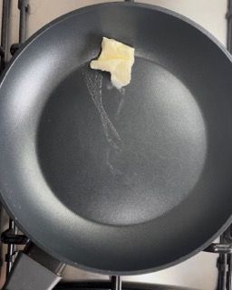 Un pezzo di burro si sta sciogliendo in una padella