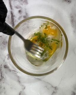 Una persona tiene una forchetta in una ciotola di cibo.