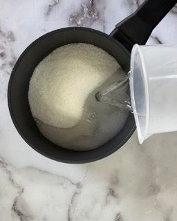Zucchero sciolto nell'acqua calda per lo sciroppo