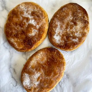 Tre pasticcini ricoperti di zucchero a velo sono su una superficie di marmo