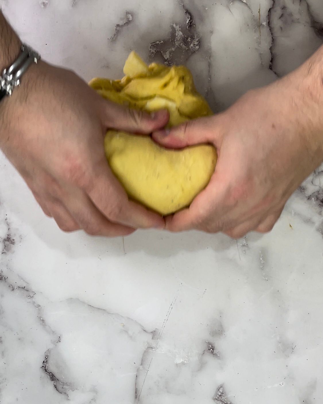 Una persona tiene in mano un pezzo di pasta.