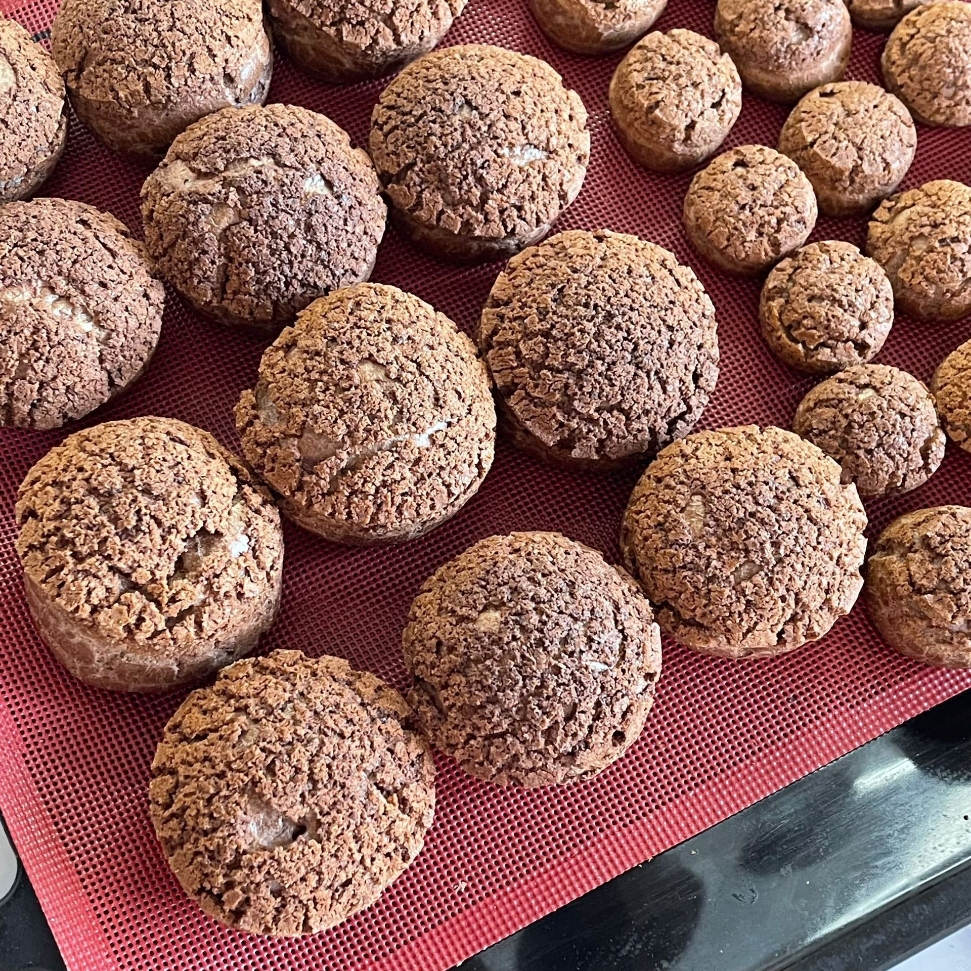 Un mucchio di palline di cioccolato sono appoggiate su un tappetino rosso.