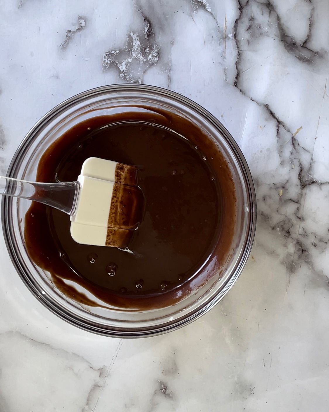 Una ciotola di salsa al cioccolato con una spatola dentro