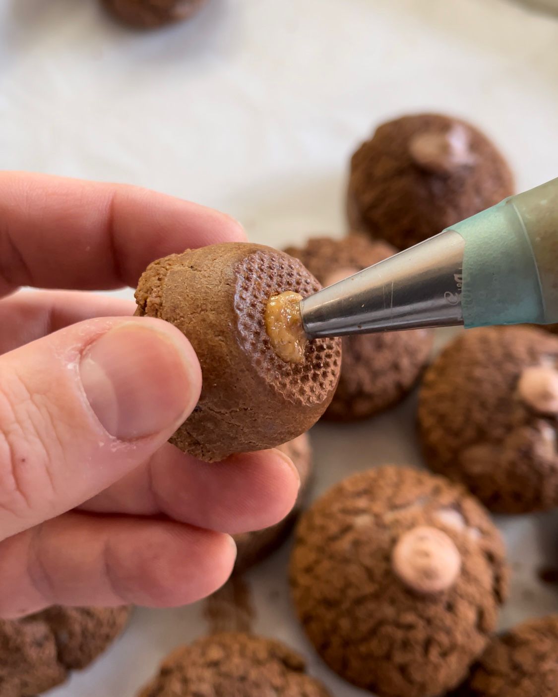 Una persona sta decorando un biscotto con una sac à poche.