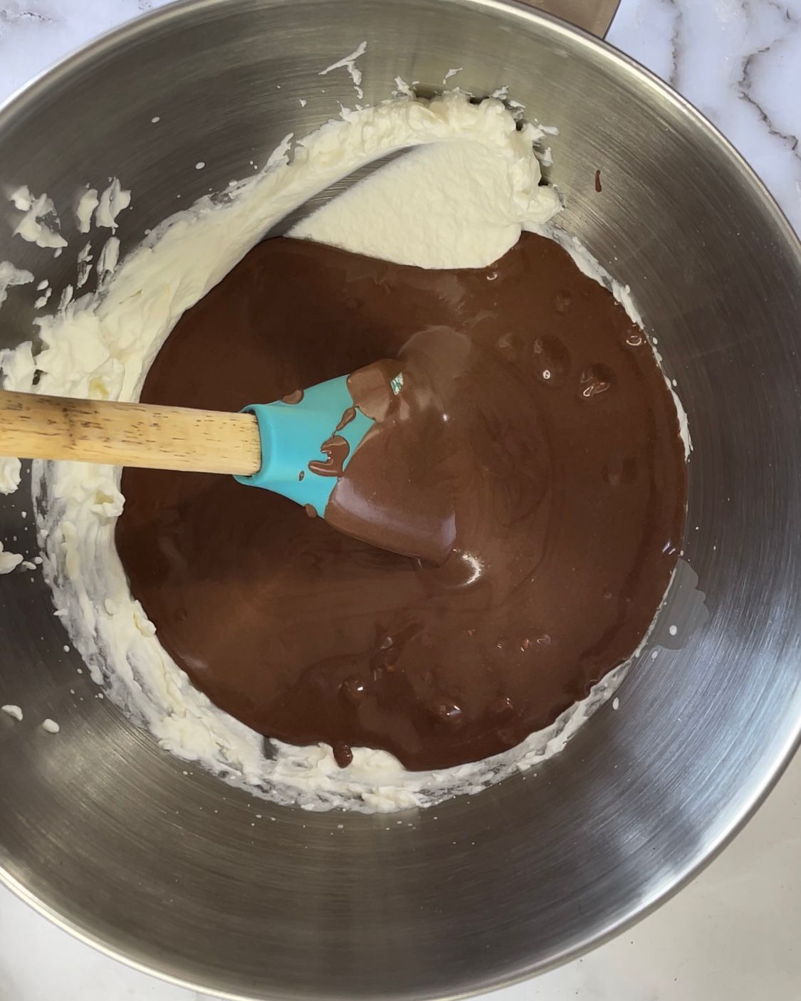 Una ciotola di cioccolato e panna montata con una spatola dentro