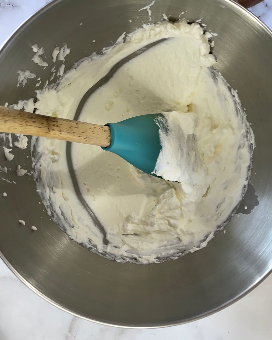 Una ciotola di panna montata con una spatola dentro