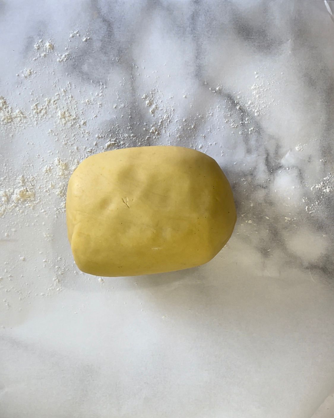 Una palla di pasta è appoggiata su una superficie di marmo.