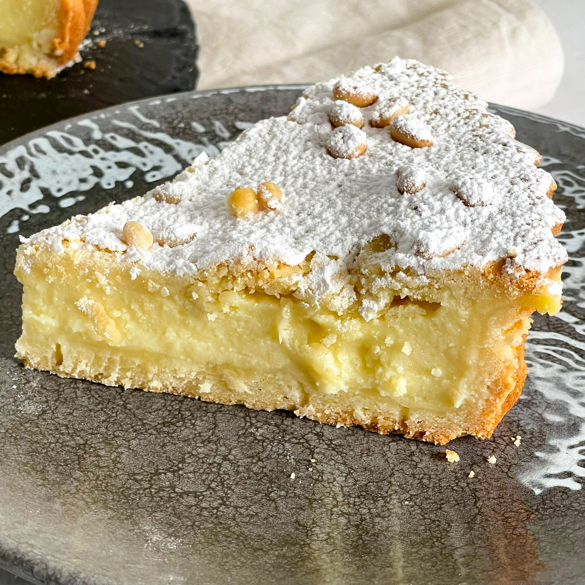 Una fetta di torta con sopra dello zucchero a velo è su un piatto.