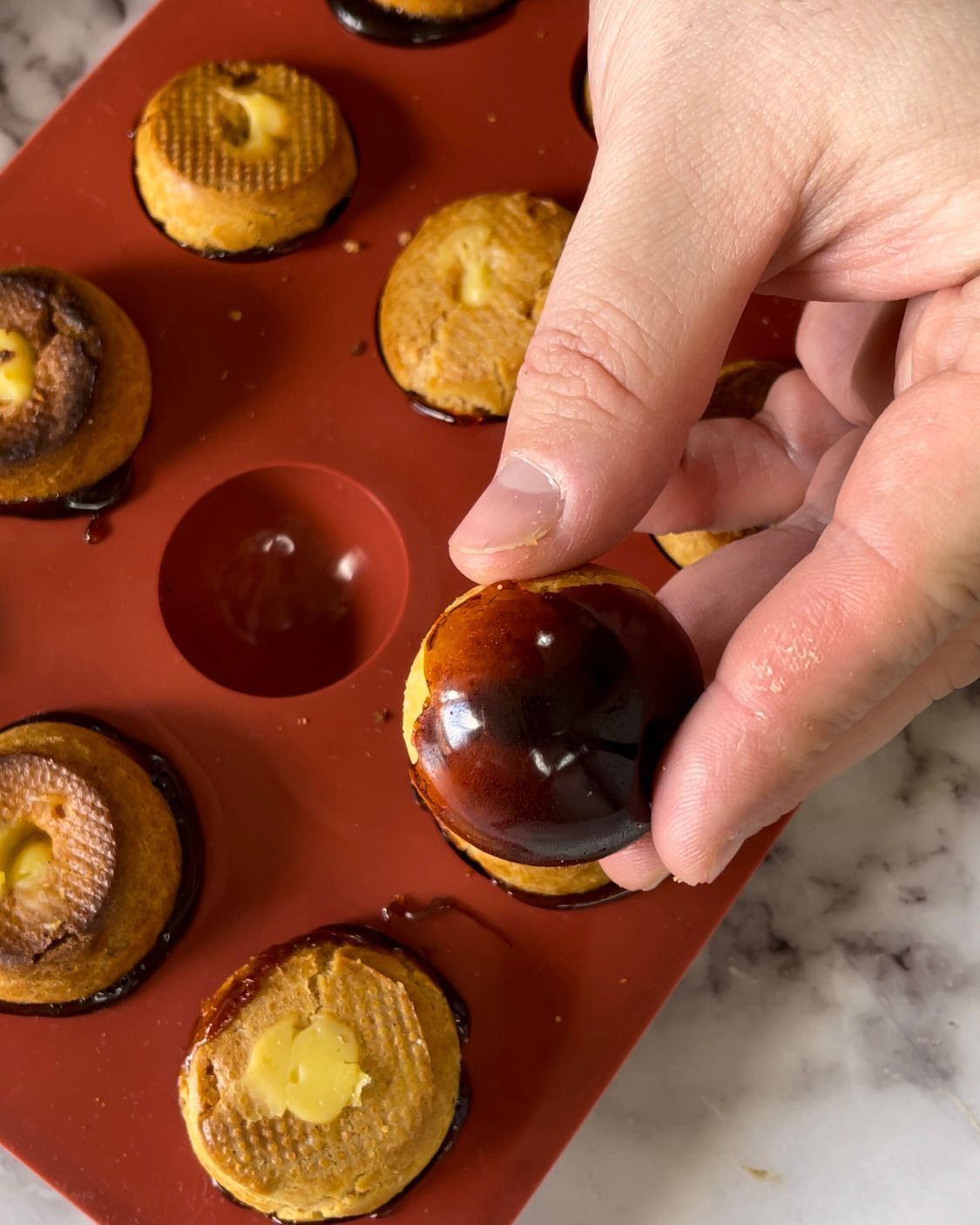Una persona sta mettendo un biscotto in uno stampo per muffin