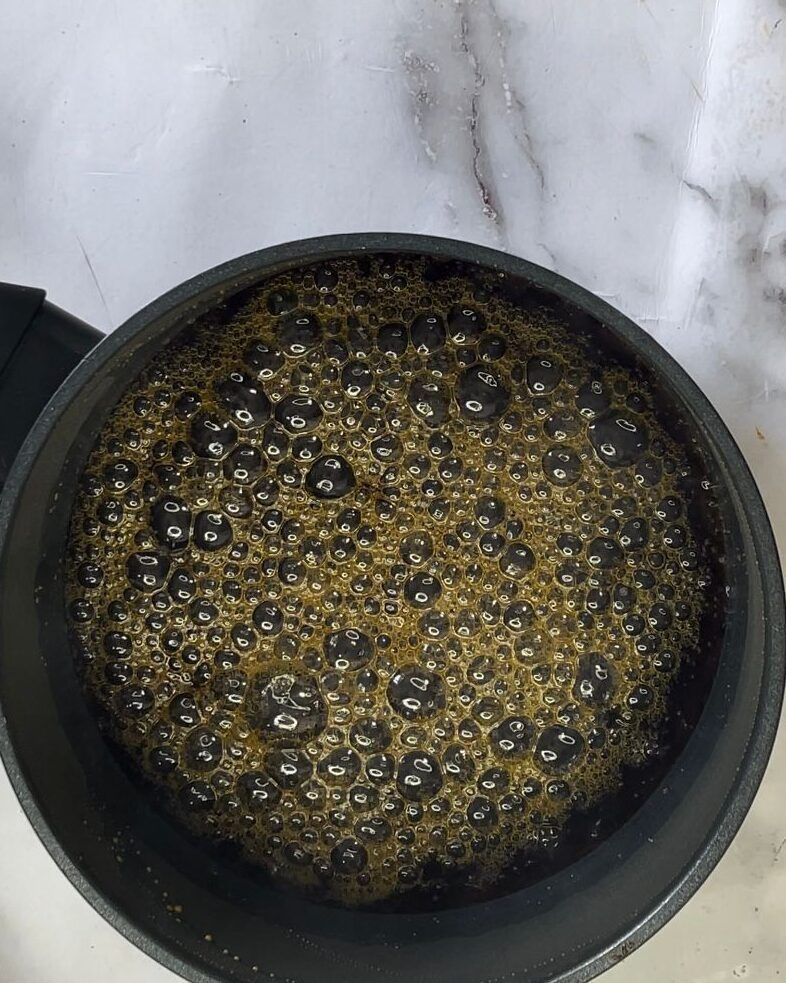 Un primo piano di un vaso contenente un liquido con delle bollicine al suo interno.