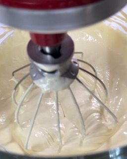 Un primo piano di un mixer con panna montata al suo interno.