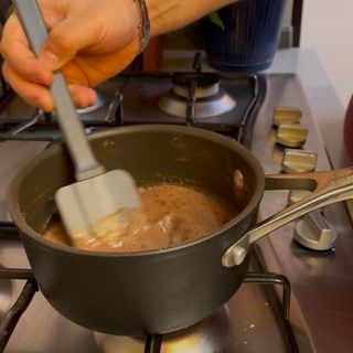 Una persona sta mescolando una pentola di liquido con una spatola