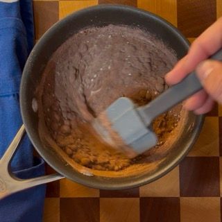 Una persona sta mescolando una pentola di cibo con una spatola