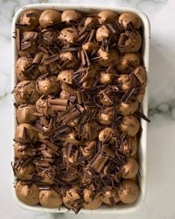 Una teglia bianca piena di palline e scaglie di cioccolato.