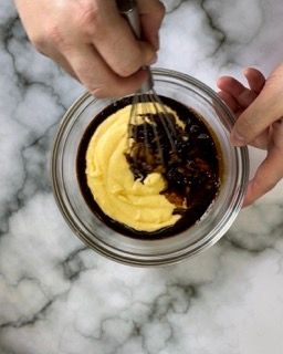 Una persona sta mescolando la salsa in una ciotola con una frusta.