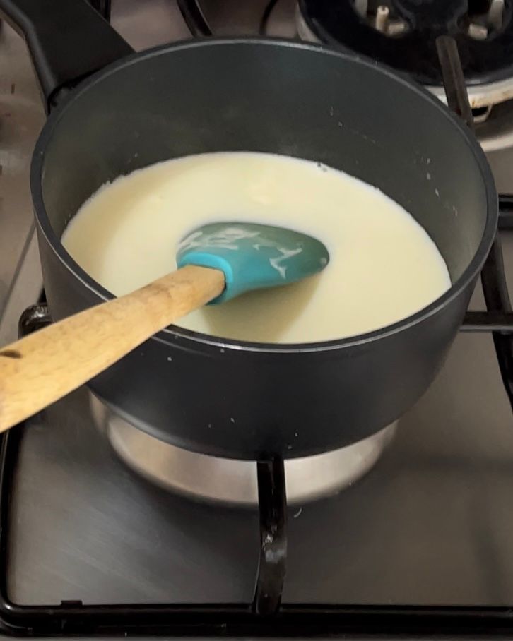 Una pentola di liquido con dentro un cucchiaio di legno