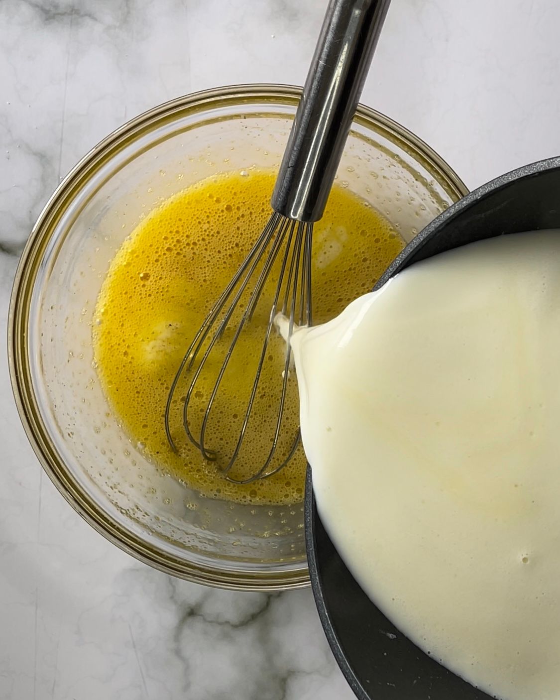 Una frusta viene versata in una ciotola di uova