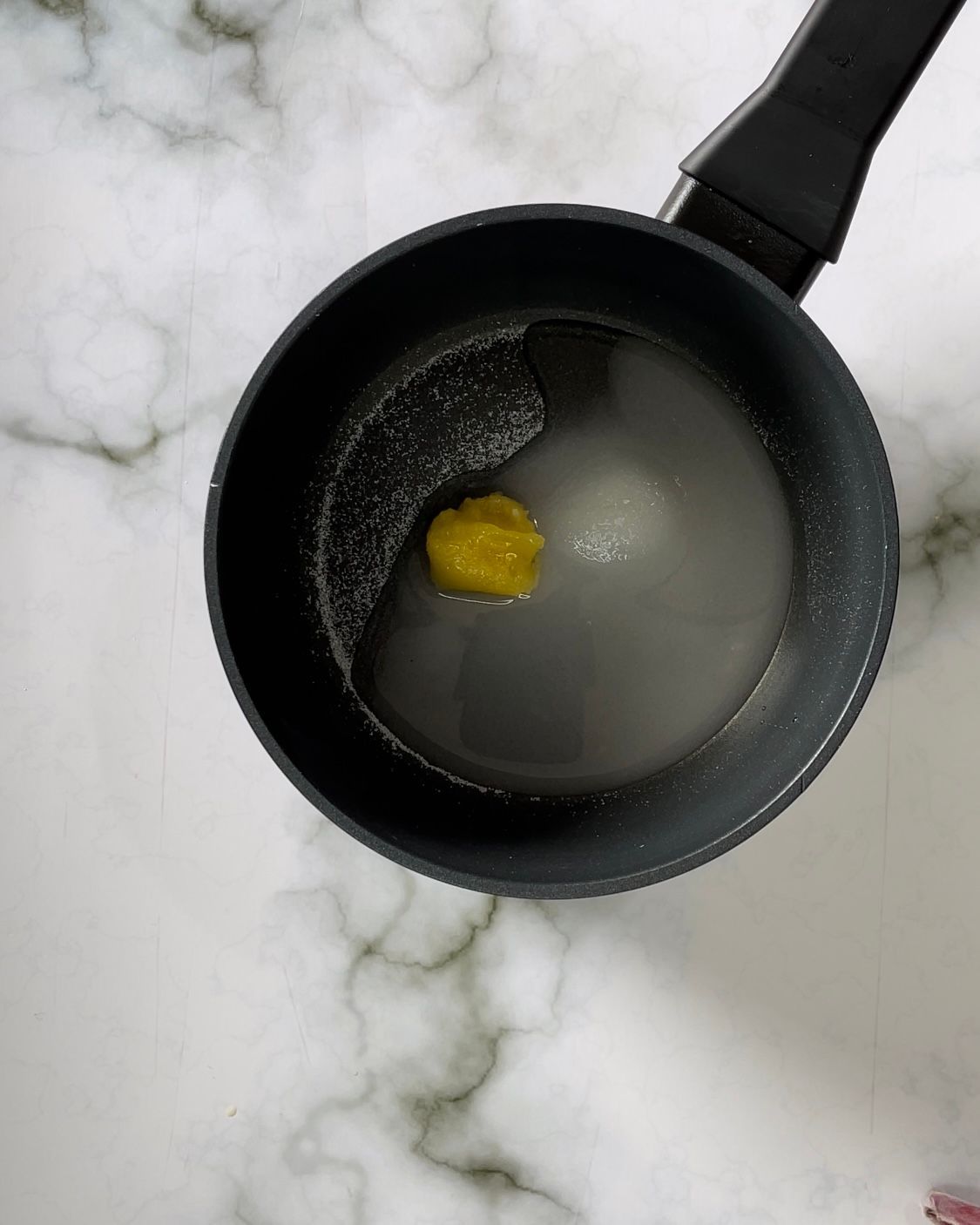 Una pentola piena di liquido con un oggetto giallo dentro.