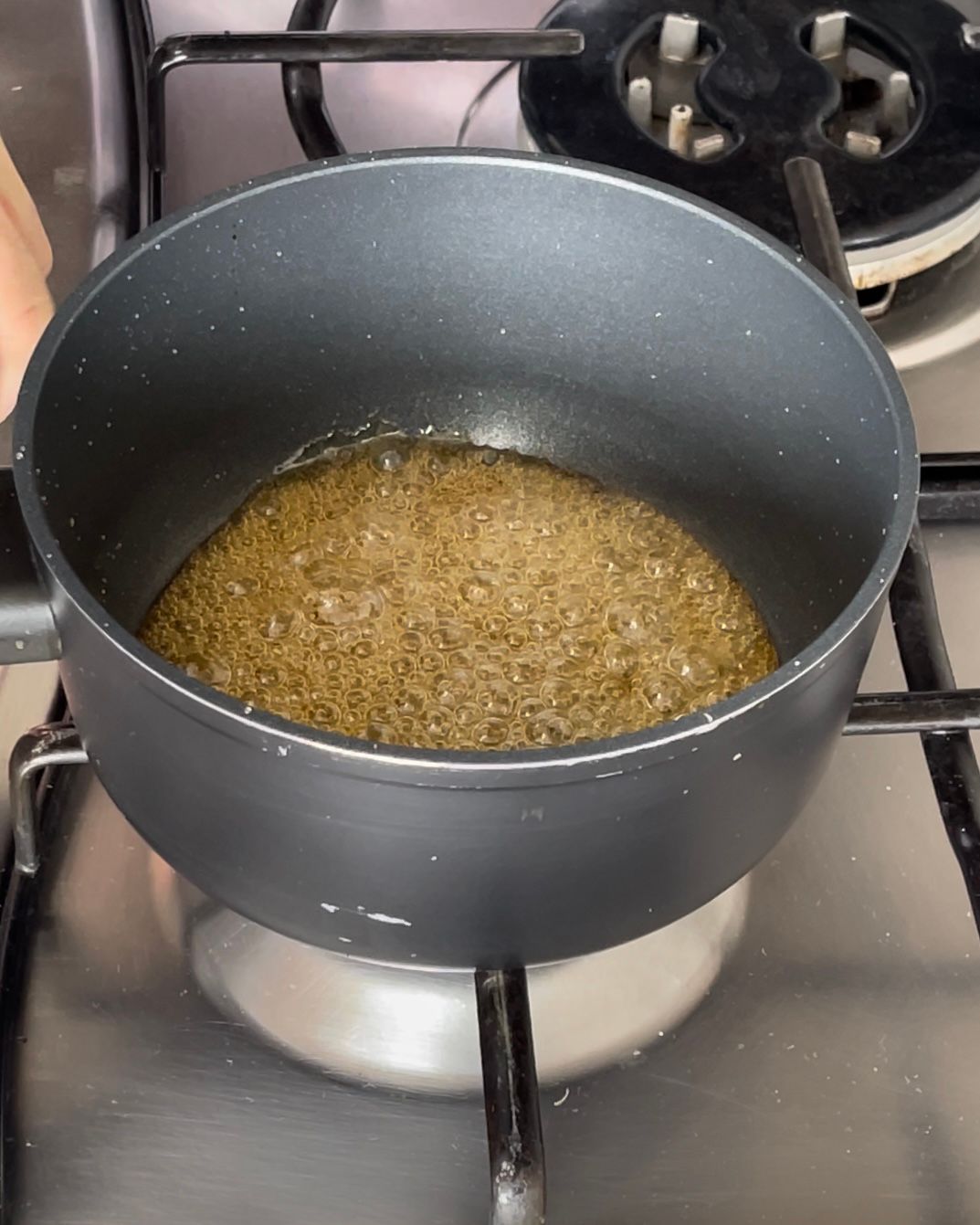 Una pentola di liquido marrone sta cuocendo su un fornello