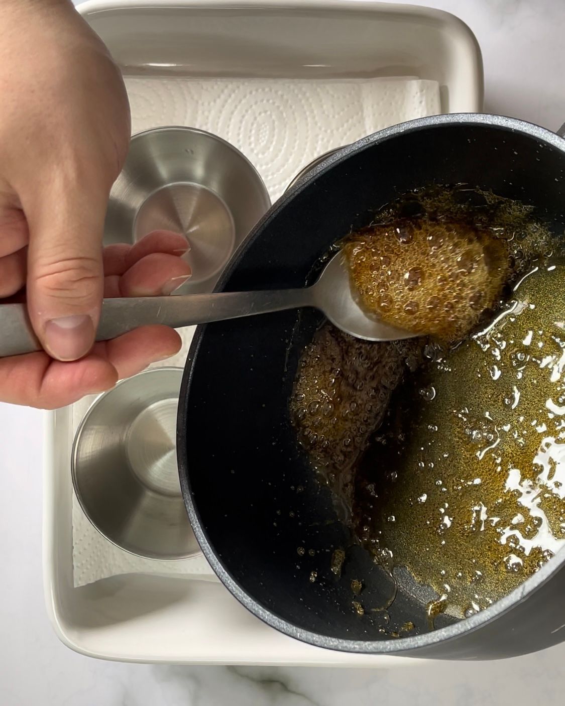 Una persona tiene un cucchiaio sopra una ciotola di cibo.