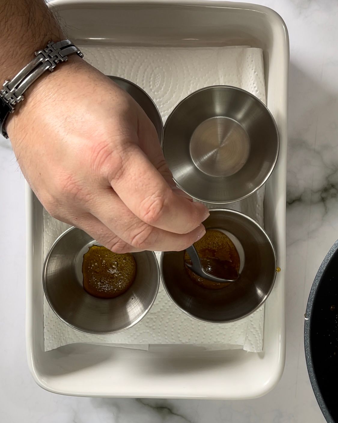 Una persona tiene in mano un cucchiaio in una ciotola piena di liquido.