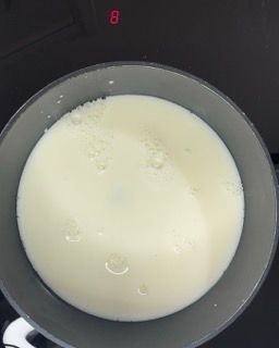 Una ciotola piena di liquido bianco è appoggiata sul fornello.