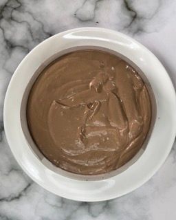 Una ciotola di salsa al cioccolato su una superficie di marmo