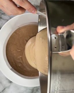 Una persona sta mescolando qualcosa in una ciotola con un cucchiaio.