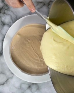 Una persona versa la pastella in una ciotola con un cucchiaio.