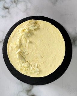 Una torta gialla con scaglie di cioccolato bianco sopra