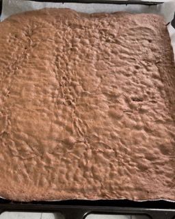 Un pezzo di torta al cioccolato è appoggiato su una teglia.