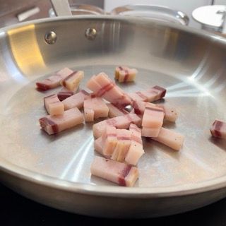 Una padella piena di pancetta tritata su un tavolo