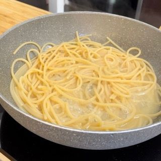 Gli spaghetti vengono cotti in una padella sul fornello