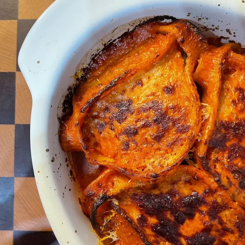 Primo piano Teglia di conchiglioni ripieni al forno gratinati con sugo di pomodoro e parmigiano.