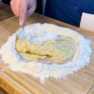 Una persona sta mescolando qualcosa in una ciotola di farina