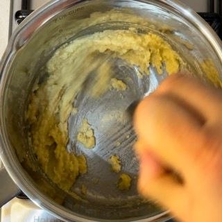 Una persona sta mescolando una pentola di cibo con un cucchiaio