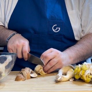 Una persona che indossa un grembiule blu con la lettera g sopra