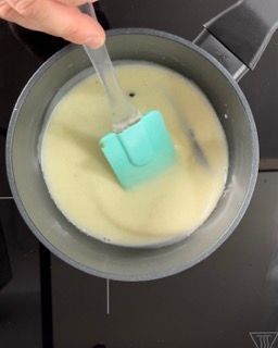 Una persona sta mescolando una ciotola di liquido con una spatola.