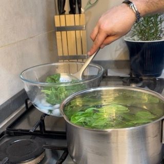 Una persona sta mescolando una pentola d'acqua con un cucchiaio