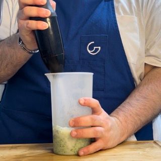 Un uomo che indossa un grembiule con la lettera g sopra