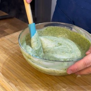 Una persona sta mescolando qualcosa in una ciotola con una spatola