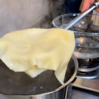 Un pezzo di cibo viene versato in una pentola di acqua bollente