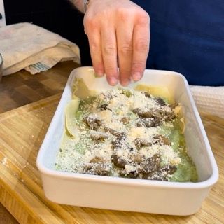 Una persona sta mettendo il formaggio in una casseruola