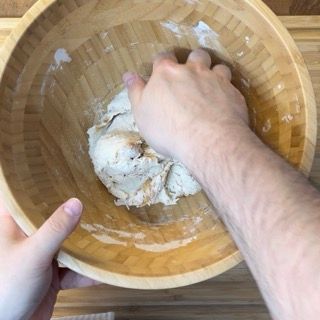 Una persona sta mescolando qualcosa in una ciotola di legno