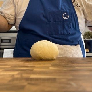 Una persona che indossa un grembiule blu con la lettera g sopra