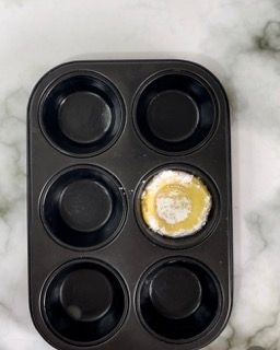 Uno stampo per muffin con quattro tazze di impasto al suo interno.