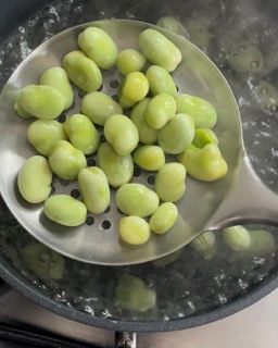 I fagiolini vengono tirati fuori da una pentola di acqua bollente